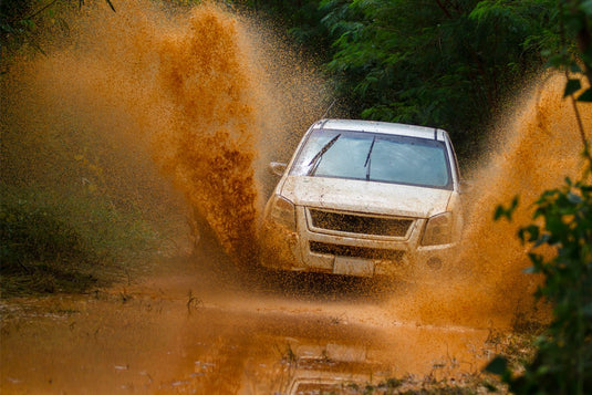 ute driving through a muddy pool of water