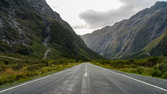 empty highway road, road winding through valley, beautiful steep hills either side