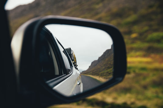 rear vision mirror, showing country road behind