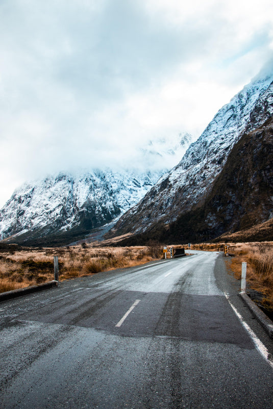 driving down icy road into snowy mountains 