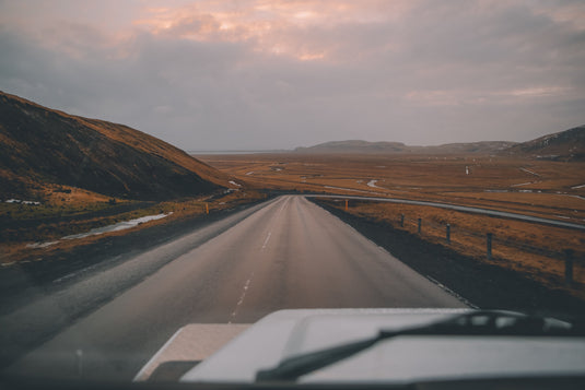 ute driving down deserted highway, cloudy day, bare country scenery