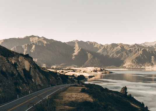 back country new zealand road, driving into a valley by a lake